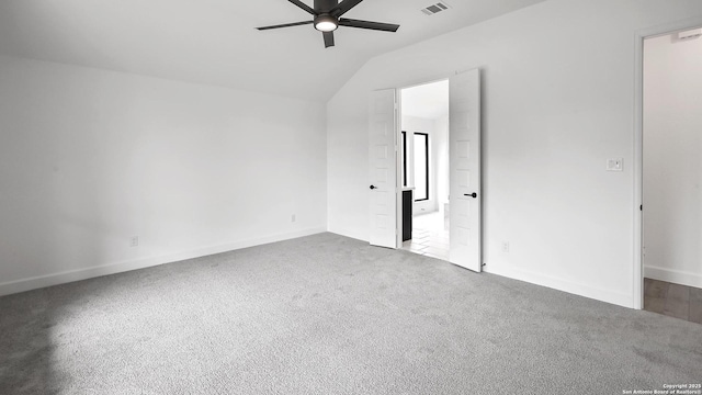 unfurnished bedroom featuring baseboards, carpet, vaulted ceiling, and visible vents