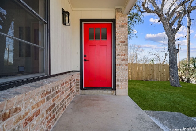 property entrance featuring a lawn