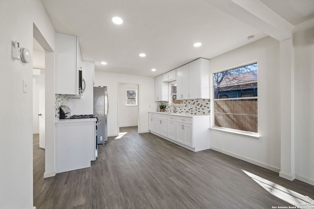 kitchen with sink, stainless steel appliances, white cabinetry, and tasteful backsplash