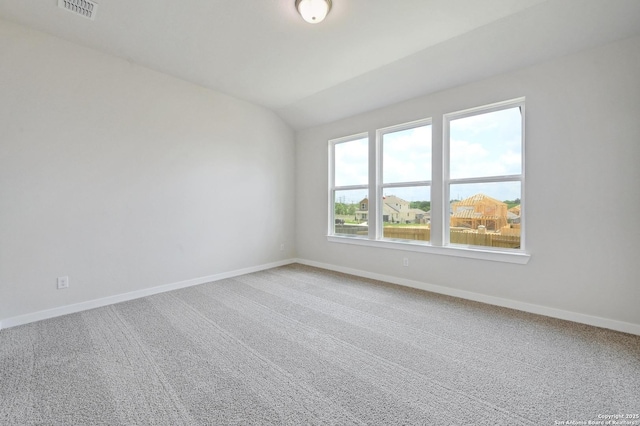 empty room featuring baseboards, carpet, and lofted ceiling