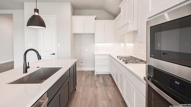 606 Inner Path, New Braunfels, TX 78132 - kitchen featuring hanging light fixtures, a sink, light countertops, light wood-style flooring, and white cabinetry