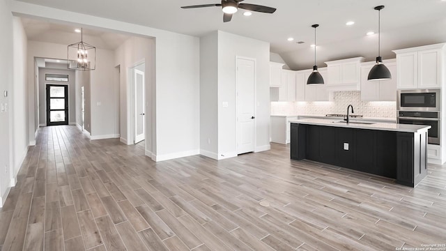 606 Inner Path, New Braunfels, TX 78132 - kitchen with light countertops, light wood finished floors, appliances with stainless steel finishes, and decorative backsplash