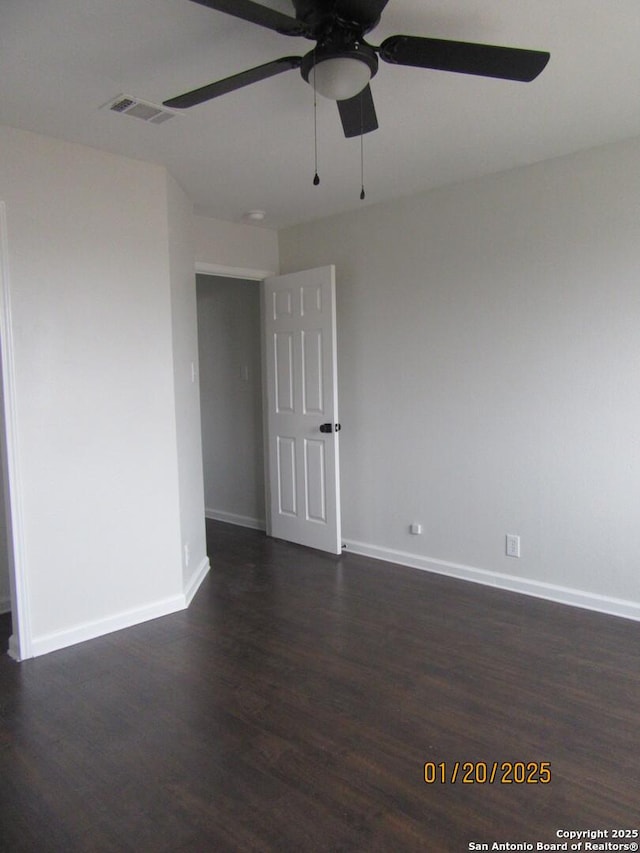 empty room with dark wood-type flooring and ceiling fan