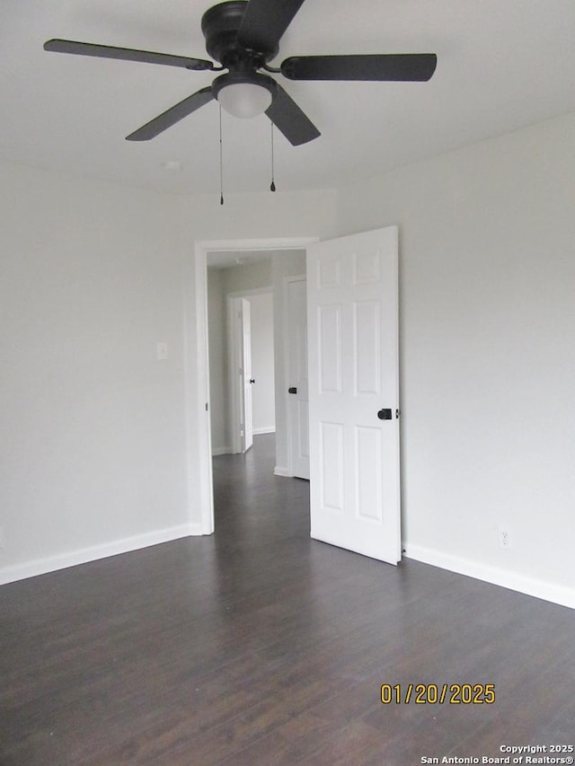 unfurnished room featuring ceiling fan and dark wood-type flooring