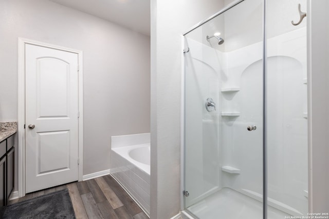 bathroom featuring wood-type flooring, separate shower and tub, and vanity