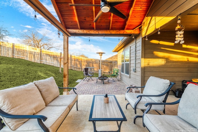 view of patio with ceiling fan and an outdoor living space with a fire pit