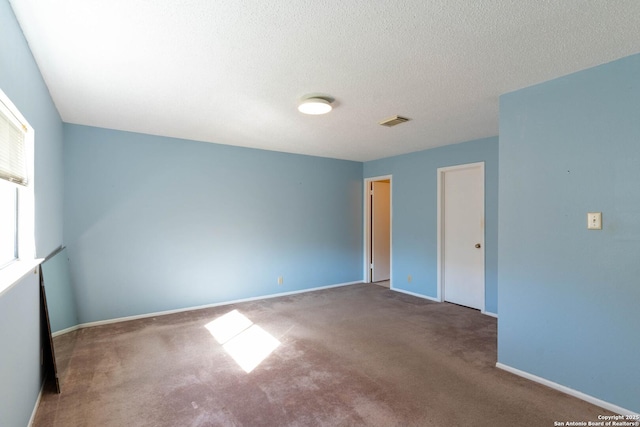 empty room with carpet and a textured ceiling