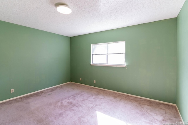 carpeted spare room with a textured ceiling