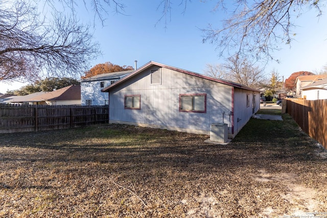 back of house featuring a lawn and central AC