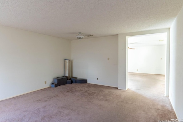 unfurnished room with a textured ceiling and light colored carpet