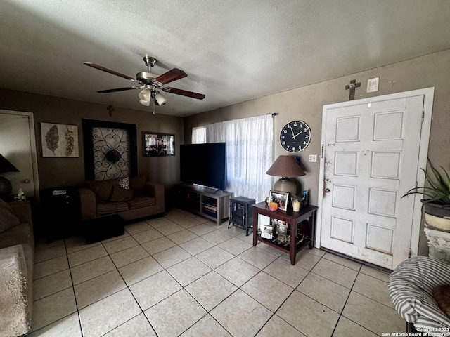 living room with a textured ceiling, light tile patterned floors, and ceiling fan