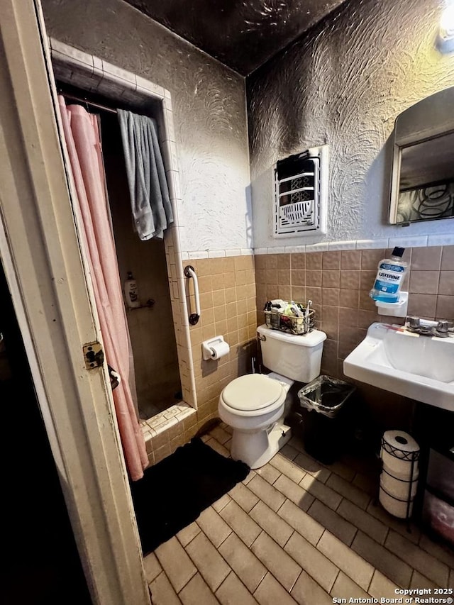 bathroom with tile walls, toilet, heating unit, and a shower with curtain