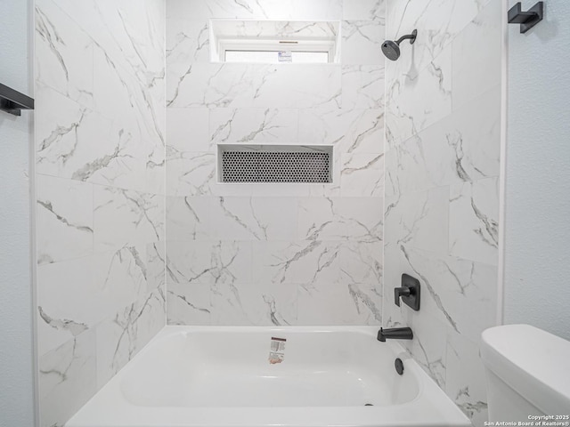 bathroom featuring toilet and tiled shower / bath combo