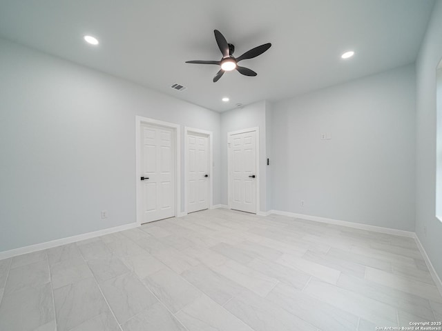 unfurnished bedroom featuring multiple closets and ceiling fan