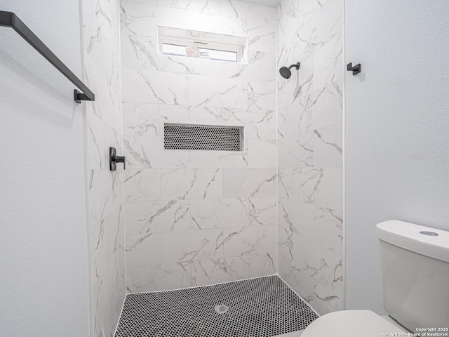 bathroom with tiled shower and toilet