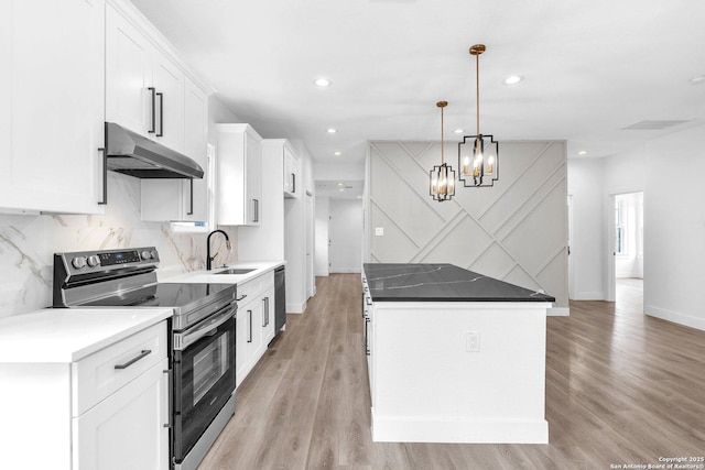 kitchen featuring a center island, white cabinetry, sink, decorative light fixtures, and electric range