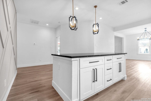 kitchen featuring white cabinetry, hanging light fixtures, and a healthy amount of sunlight