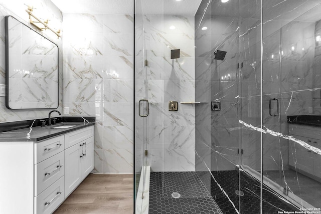 bathroom featuring hardwood / wood-style floors, an enclosed shower, and vanity