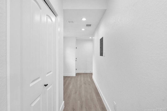 hallway featuring light wood-type flooring and electric panel