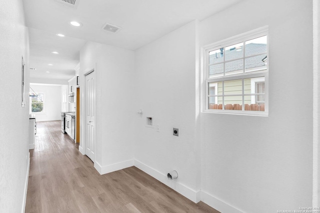 washroom with hookup for an electric dryer, light hardwood / wood-style floors, hookup for a washing machine, and hookup for a gas dryer