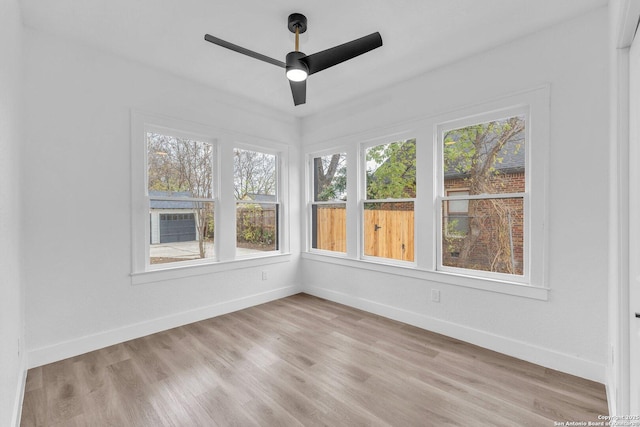 unfurnished sunroom featuring ceiling fan