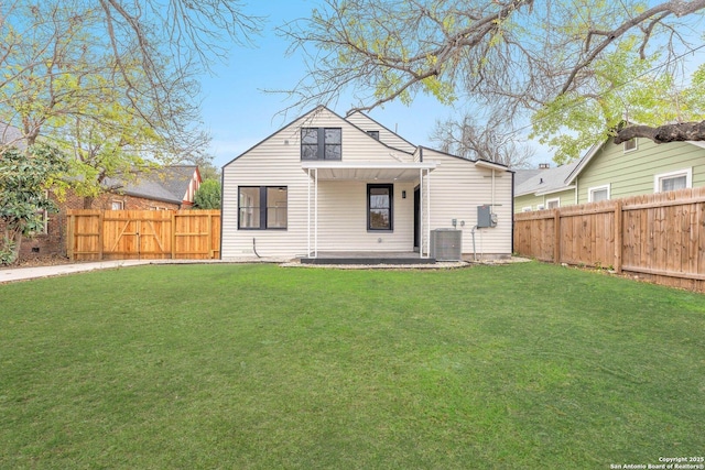 rear view of property with a yard and central AC