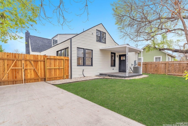 view of front of home with covered porch, a front yard, and central AC unit