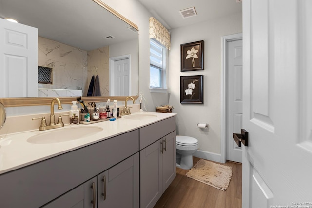 bathroom featuring wood-type flooring, toilet, and vanity