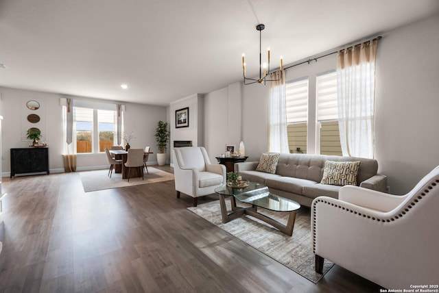 living room featuring wood-type flooring and an inviting chandelier