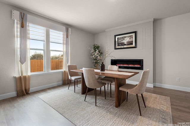 dining area featuring wood-type flooring and a healthy amount of sunlight