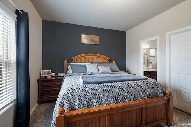 bedroom featuring ensuite bathroom and carpet floors