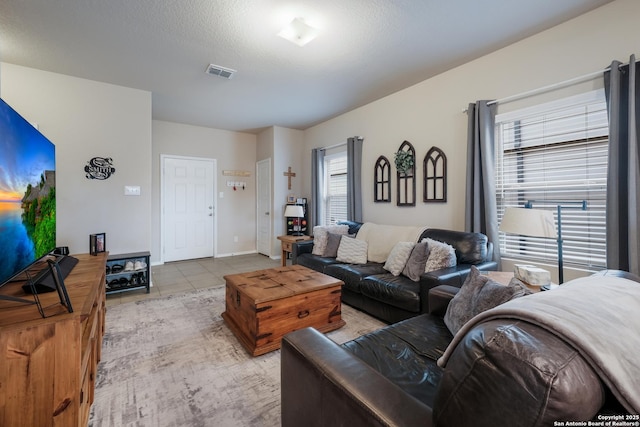 tiled living room featuring a textured ceiling