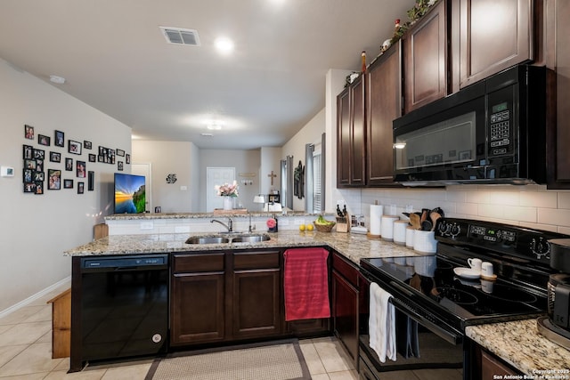 kitchen with black appliances, kitchen peninsula, light tile patterned floors, and sink