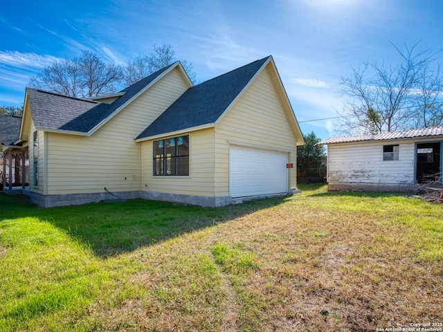 view of side of home featuring a garage and a yard