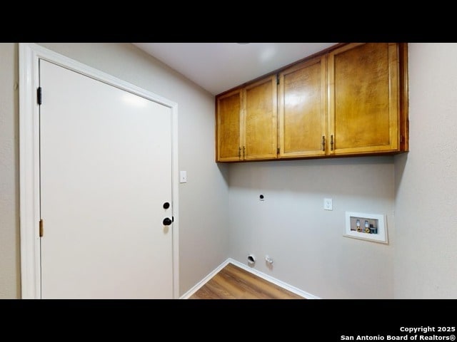 laundry room featuring wood-type flooring, washer hookup, gas dryer hookup, electric dryer hookup, and cabinets