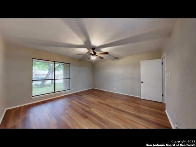 empty room featuring ceiling fan and hardwood / wood-style floors