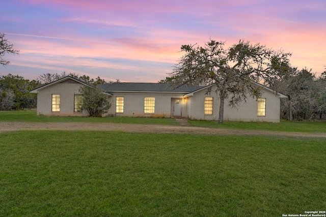 single story home featuring a lawn