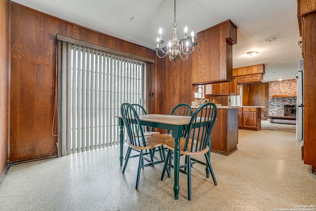 dining area featuring wooden walls and an inviting chandelier