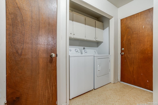 clothes washing area featuring washer and dryer and cabinets