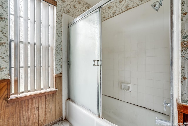 bathroom with wooden walls and enclosed tub / shower combo