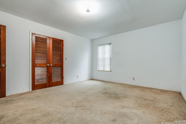 carpeted spare room featuring french doors