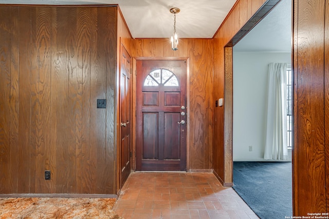 entryway with wooden walls and carpet floors