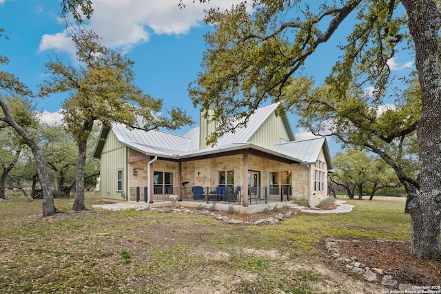 rear view of property with a lawn and covered porch