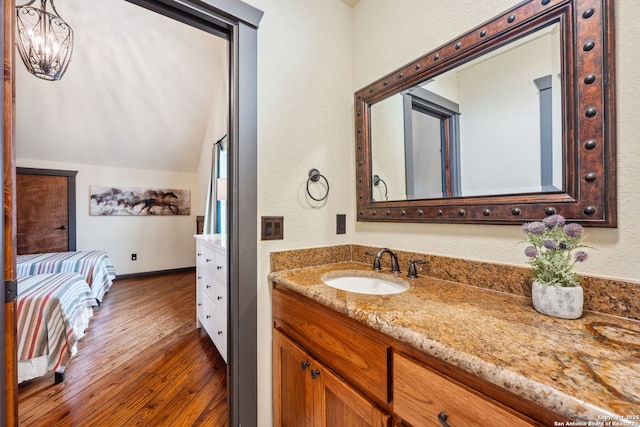 bathroom with vanity, wood-type flooring, and lofted ceiling