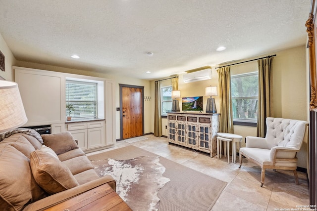 living room with a wall unit AC and a textured ceiling