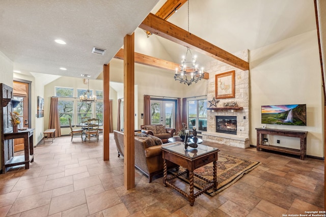 living room with beamed ceiling, a healthy amount of sunlight, a fireplace, and a chandelier