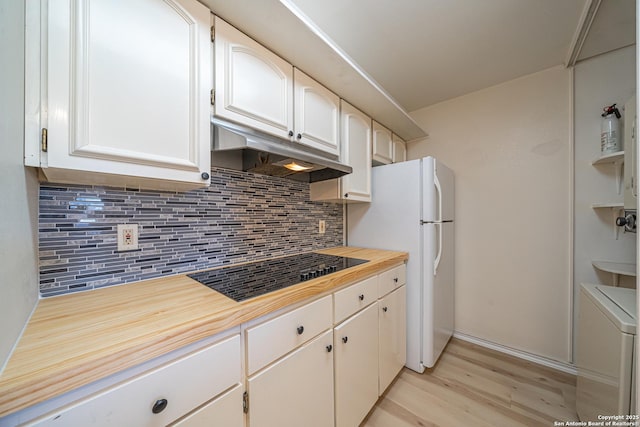 kitchen with white cabinets, black stovetop, washer / dryer, and tasteful backsplash