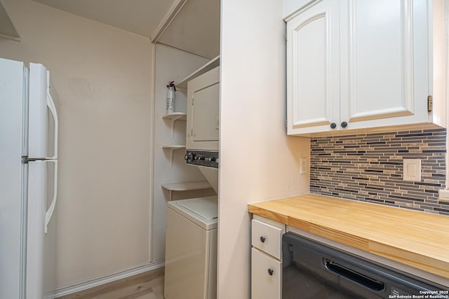 clothes washing area with light hardwood / wood-style floors and stacked washer and dryer