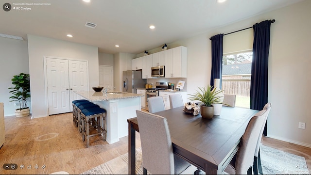 dining area featuring sink and light hardwood / wood-style flooring