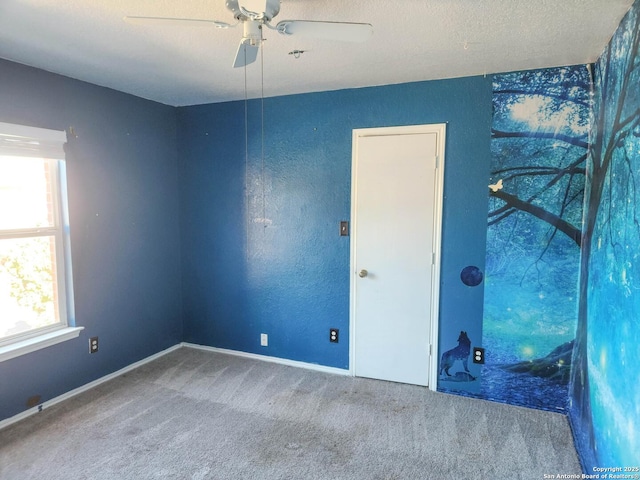 carpeted empty room with a healthy amount of sunlight, a textured ceiling, and ceiling fan